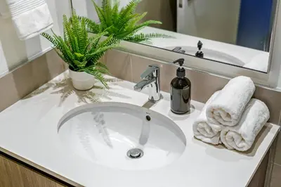 a bathroom sink with a towel and a mirror at Brand New 1BR in Dubai Hills Quiet and Peaceful in Dubai