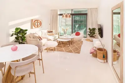 a living room with a table and chairs at prime retreats - beach vista Emaar in Dubai