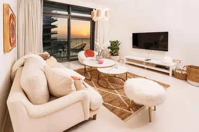 a living room with a couch and a tv at prime retreats - beach vista Emaar in Dubai