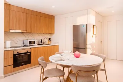 a kitchen with a table and chairs in a kitchen at prime retreats - beach vista Emaar in Dubai
