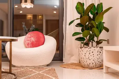 a red apple sitting in a chair next to a plant at prime retreats - beach vista Emaar in Dubai