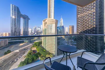 a balcony with chairs and a table in a city at Maison Privee - Balinese Style Apt in the Heart of Downtown Dubai in Dubai