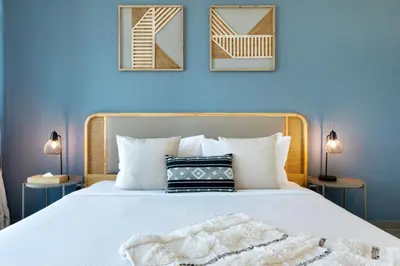 a bedroom with a bed with white sheets and pillows at Maison Privee - Balinese Style Apt in the Heart of Downtown Dubai in Dubai