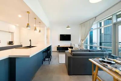 a kitchen and living room with a couch and a table at Maison Privee - Balinese Style Apt in the Heart of Downtown Dubai in Dubai