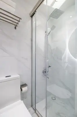 a bathroom with a glass shower with a toilet at Luxury Apt - Rooftop Pool - City View in Dubai