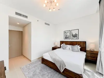 a white bedroom with a large bed and a chandelier at Modern 3BR in Marina, Sea View Next to Bluewater - 28AB02 in Dubai