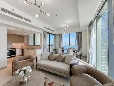 a living room with a couch and chairs and a kitchen at Modern 3BR in Marina, Sea View Next to Bluewater - 28AB02 in Dubai