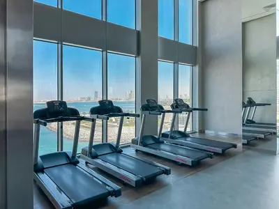 a row of treadmills in a room with windows at Modern 3BR in Marina, Sea View Next to Bluewater - 28AB02 in Dubai