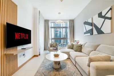 a living room with a couch and a tv at Vacay Lettings - Iris blue spectacular Marina view Apartment in Dubai
