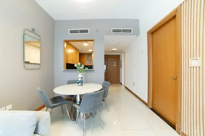 a dining room and living room with a table and chairs at Vacay Lettings - Iris blue spectacular Marina view Apartment in Dubai