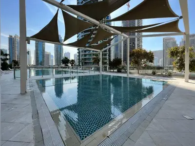 a large swimming pool in a building with a city at Vacay Lettings - Iris blue spectacular Marina view Apartment in Dubai