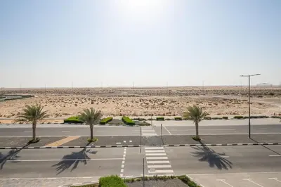 an empty parking lot with palm trees in the desert at Frank Porter - Majestique 1 in Dubai