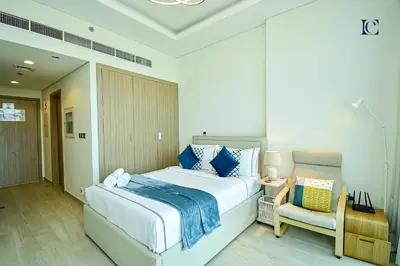 a bedroom with a large bed and a chair at Luxury Escapes - Brand New Studio with View - Azizi Farhad Jaddaf in Dubai