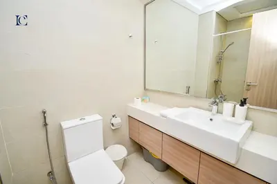 a bathroom with a sink and a toilet and a mirror at Luxury Escapes - Brand New Studio with View - Azizi Farhad Jaddaf in Dubai