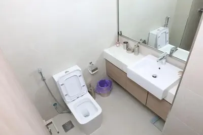 a bathroom with a sink and a toilet and a mirror at Superb Studio by The Creek view in Dubai