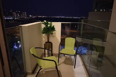 a balcony with two chairs and a potted plant at Superb Studio by The Creek view in Dubai