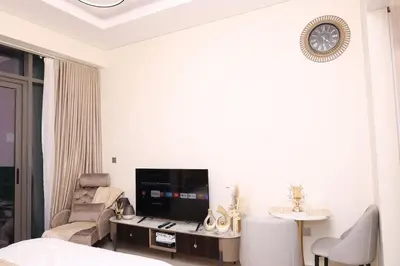 a bedroom with a bed and a tv and a chair at Superb Studio by The Creek view in Dubai