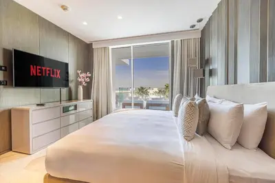 a bedroom with a large white bed and a television at Daniels Five Palm Sea View 2BR with Maids Room in Dubai