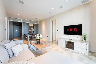a living room with a tv on a wall at Daniels Five Palm Sea View 2BR with Maids Room in Dubai
