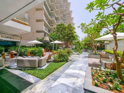 an empty courtyard of a building with chairs and umbrellas at Daniels Five Palm Sea View 2BR with Maids Room in Dubai