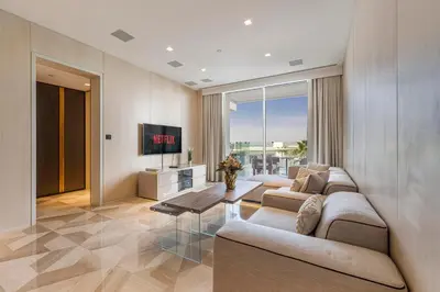 a living room with two couches and a tv at Daniels Five Palm Sea View 2BR with Maids Room in Dubai