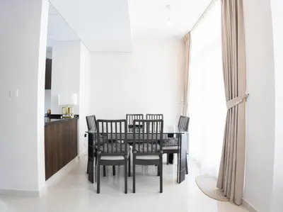 a dining room with a black table and chairs at Corner 3Bedroom Townhouse in Avencia Cluster DH2 in Dubai