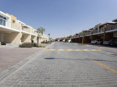 an empty street next to a row of buildings at Corner 3Bedroom Townhouse in Avencia Cluster DH2 in Dubai