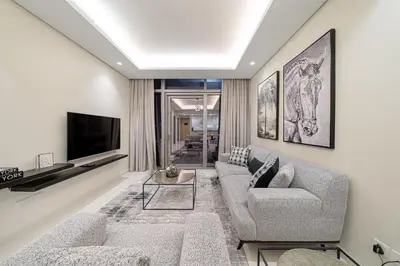 a living room with a couch and a tv at Paramount Midtown Deluxe 1 BR Apartment with Full Burj-Khalifa View in Dubai