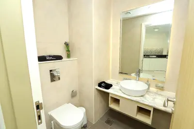 a bathroom with a sink and a toilet and a mirror at Paramount Midtown Deluxe 1 BR Apartment with Full Burj-Khalifa View in Dubai