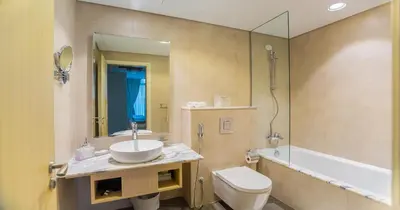 a bathroom with a sink and a toilet and a tub at Infinity Pool & Burj Khalifa View l Luxe Paramount in Dubai