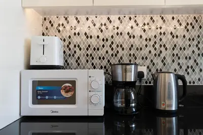 a microwave and a coffee maker on a counter at Infinity Pool & Burj Khalifa View l Luxe Paramount in Dubai