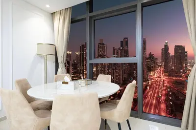 a dining room with a table and chairs and a large window at Infinity Pool & Burj Khalifa View l Luxe Paramount in Dubai