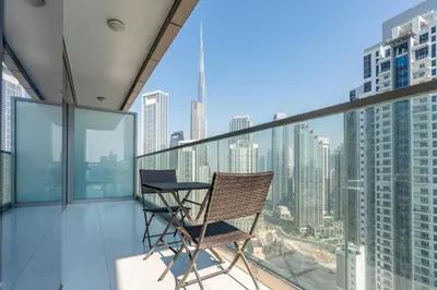 a balcony with a table and chairs on top of a building at Infinity Pool & Burj Khalifa View l Luxe Paramount in Dubai