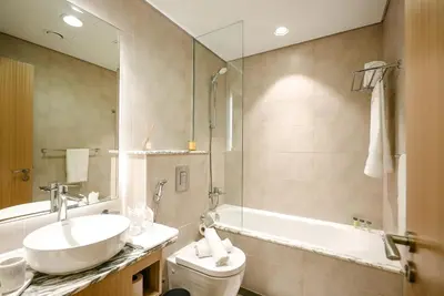 a bathroom with a sink and a tub and a toilet at Infinity Pool & Burj Khalifa View l Luxe Paramount in Dubai