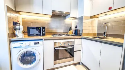 a small kitchen with a washer and dryer in it at STAY BY LATINEM Luxury 1BR Holiday Home CV A2304 near Burj Khalifa in Dubai