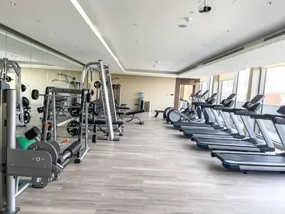 a gym with rows of treadmills and machines at STAY BY LATINEM Luxury 1BR Holiday Home CV A2304 near Burj Khalifa in Dubai