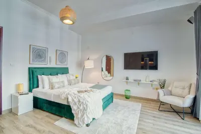 a white bedroom with a bed and a chair at The Smart Concierge - DEC Tower in Dubai