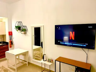 a living room with a flat screen tv on the wall at Super Elegant studio apartment-Sparkle tower By SWEET HOMES in Dubai