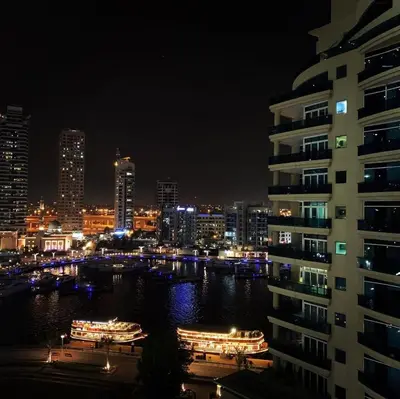 a city skyline at night with a river and buildings at Super Elegant studio apartment-Sparkle tower By SWEET HOMES in Dubai