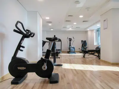 a gym with treadmills and ellipticals in a room at The Smart Concierge - Sparkle tower in Dubai