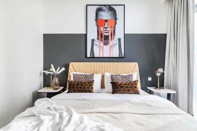 a bedroom with a bed and a painting of a clown at The Smart Concierge - Beach Vista Tower in Dubai
