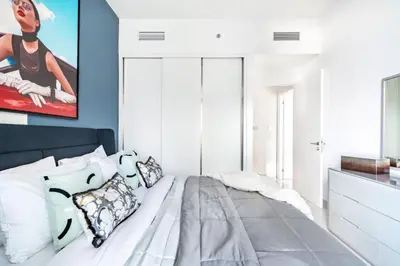 a bedroom with a large bed with blue walls at The Smart Concierge - Beach Vista Tower in Dubai