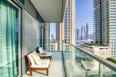a balcony with two chairs and a view of a city at The Smart Concierge - Beach Vista Tower in Dubai