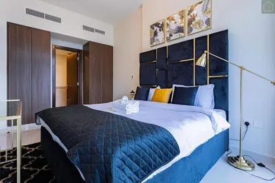 a bedroom with a large bed with a blue blanket at ONYX - Full Burj Khalifa View Dubai 2 BEDROOM APARTMENT - DOWNTOWN DUBAI in Dubai