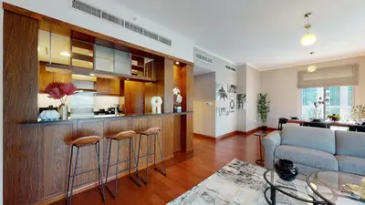 a living room with a couch and a bar with stools at Stylish 2-Bed Apt Burj Khalifa and Fountain Views in Dubai