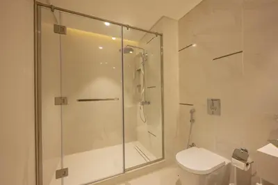 a bathroom with a glass shower and a toilet at Emaar Beach Vista Tower 1 2BHK FAHH in Dubai