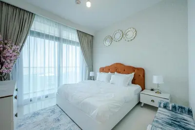 a white bedroom with a large bed and a window at Emaar Beach Vista Tower 1 2BHK FAHH in Dubai