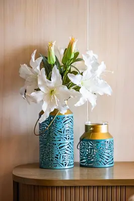 two blue and gold vases with white flowers on a table at Daniels Five Palm 2BR with Garden View in Dubai