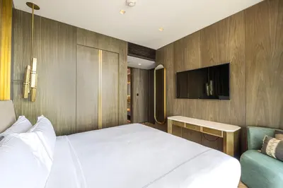 a bedroom with a white bed and a tv at Daniels Five Palm 2BR with Garden View in Dubai