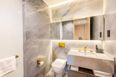 a white bathroom with a sink and a toilet at Daniels Five Palm 2BR with Garden View in Dubai